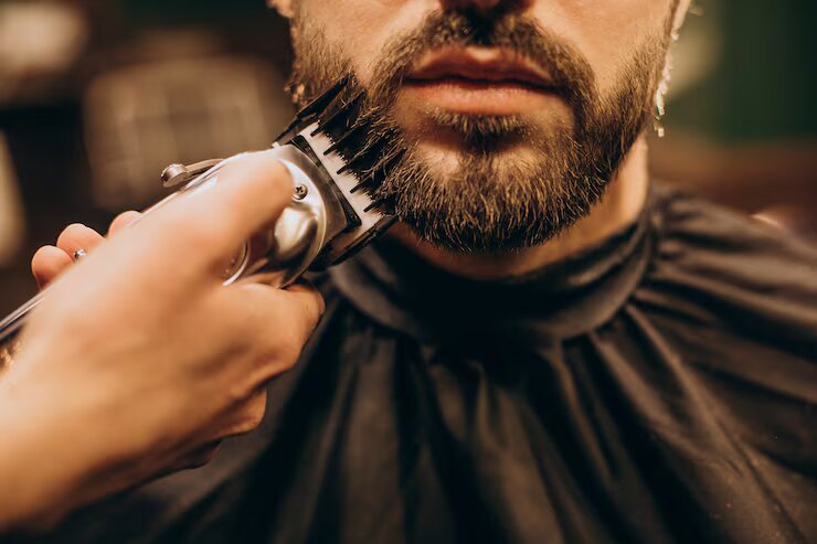 Barbeiro fazendo barba em cliente com navalha